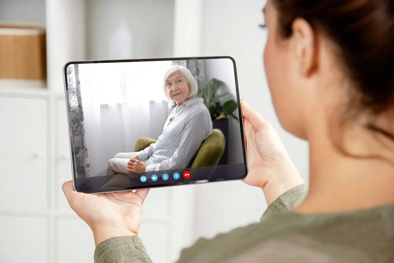 Пожилой человек использует функцию видеозвонка на своём устройстве.